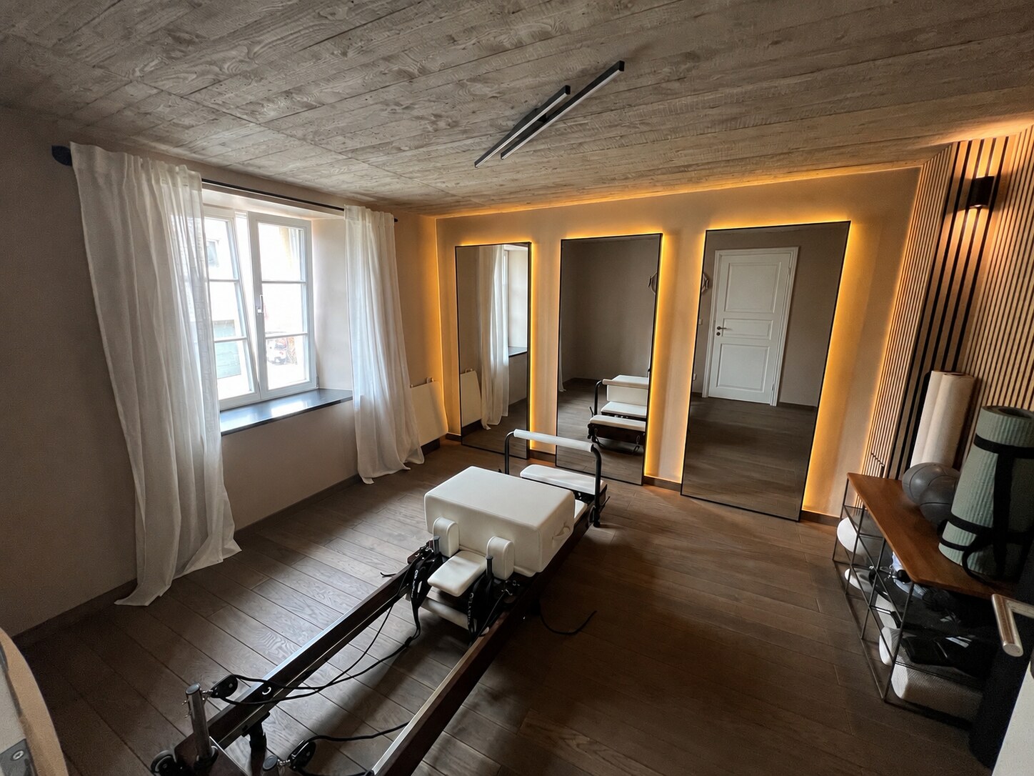 Vue du studio MB.STUDIO avec le Reformer et les miroirs rétroéclairés