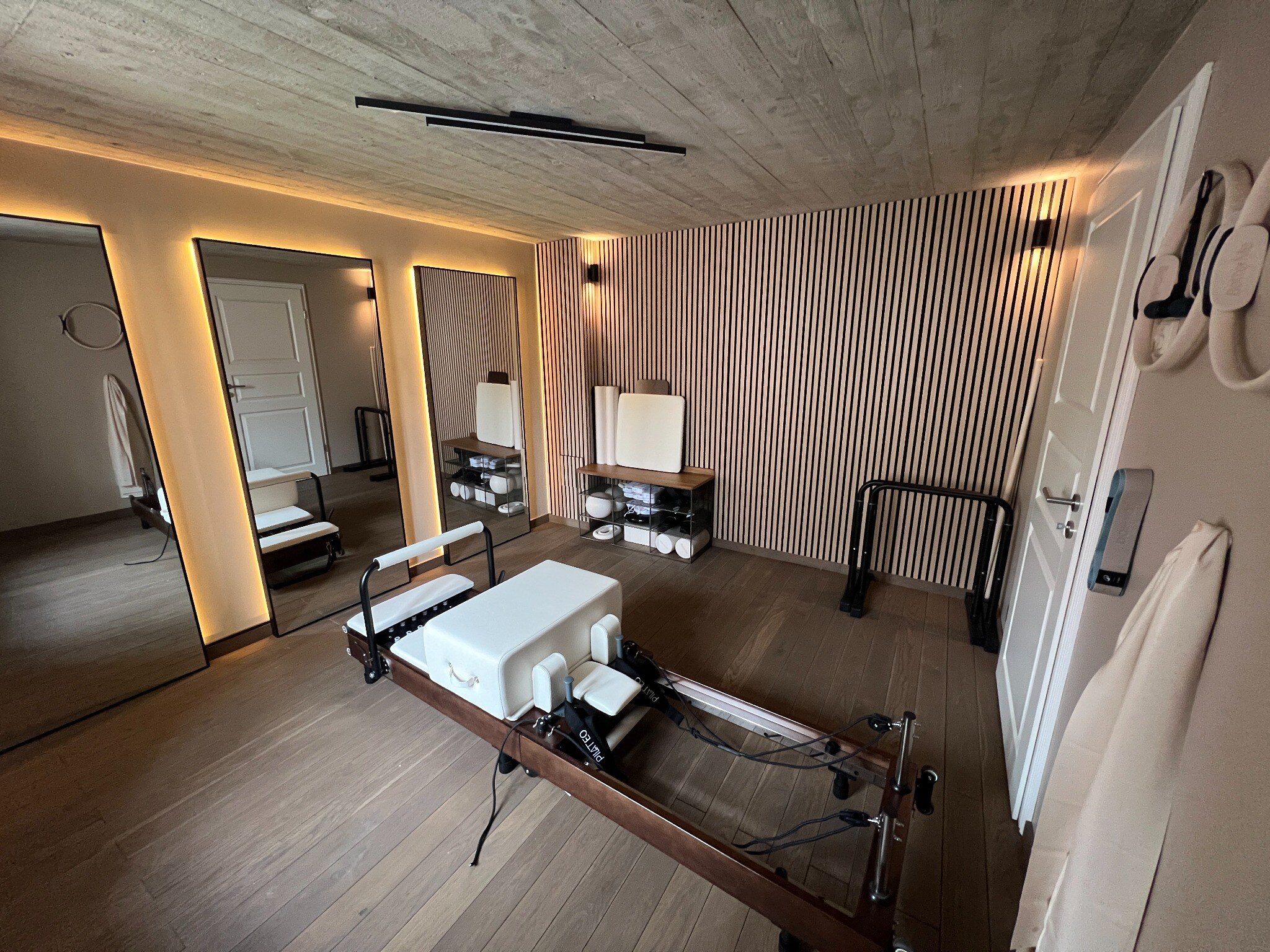 Vue du Pilates Reformer et du mur en lattes de bois du studio